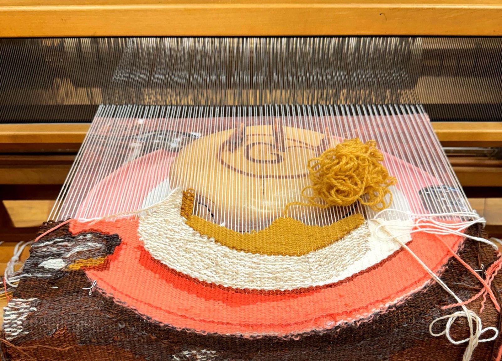 The cartoon pinned under the warp with weaving under way.